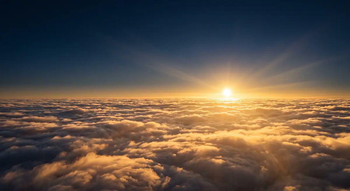 Die Sonne geht über einem goldenen Wolkenmeer auf.